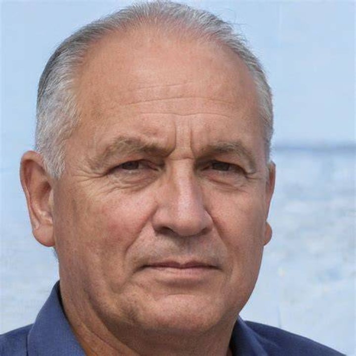 an older man in a black suit posing for a photo